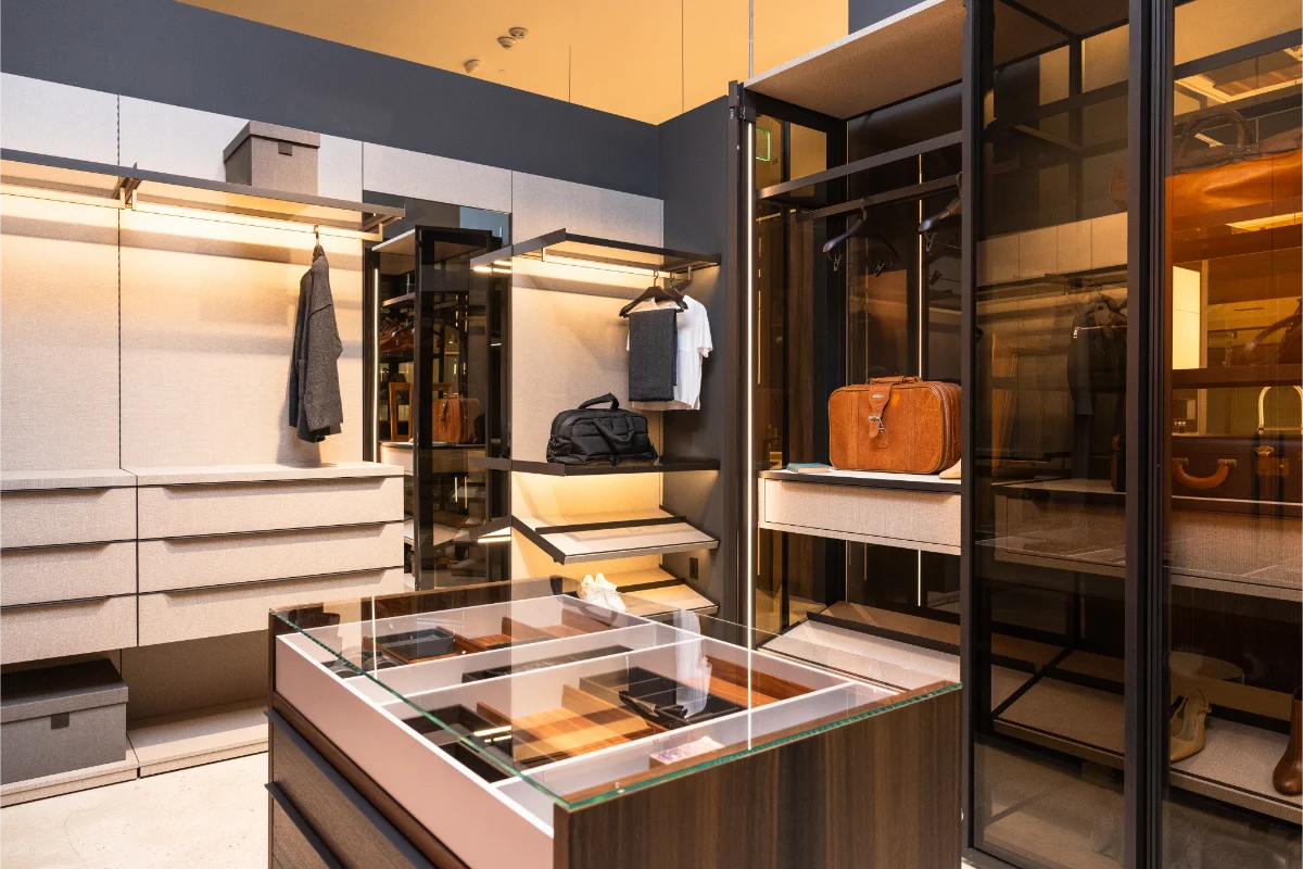 Custom wardrobe and closet display at Rastelli's Los Angeles showroom featuring integrated lighting, glass-front storage panels, and a built-in jewelry and accessory case